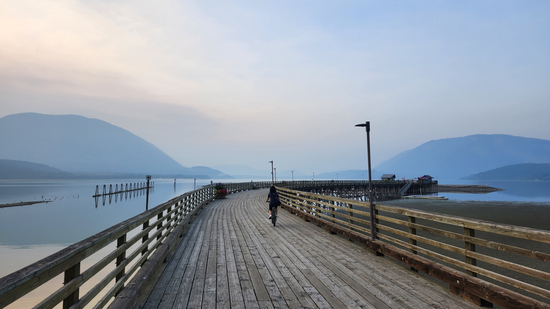 The curved wooden wharf reaching into Shuswap Lake at Marine Peace Park